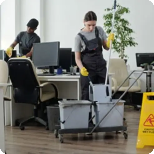Person squeezing a mop in a bucket with professional janitorial equipment in an office