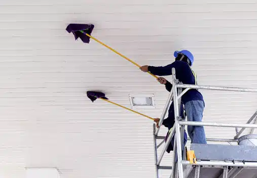 Workers cleaning the ceiling of a facility