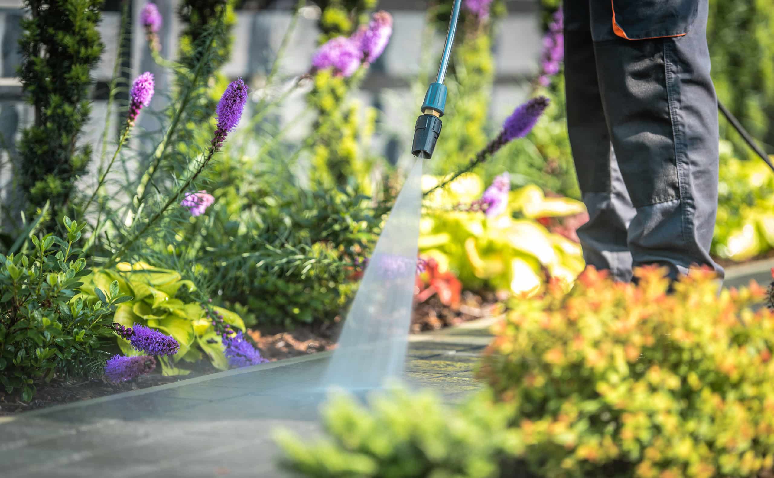 Closeup of power washing exterior walkway